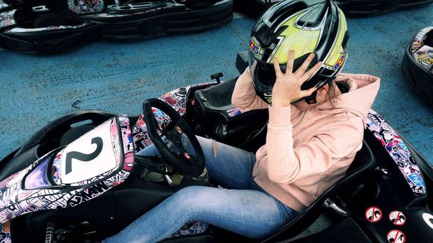 Bansko, Bulgaria - 13 Aug, 2018: Young girl take off a helmet protection after go-kart race - Foto, Imagen