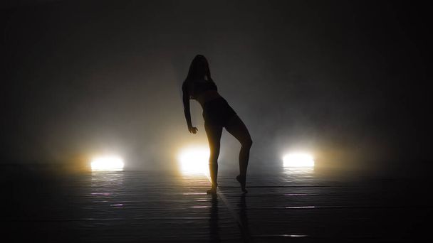 Young beautiful contemporary  ballerina on smoke stage dancing modern ballet - Foto, afbeelding