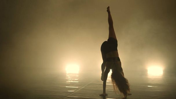 Female Dancer performing in the dark lighted room - Photo, image
