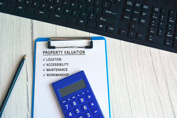 Valutazione della proprietà testo della lista di controllo sulla scheda clip blu con calcolatrice, penna e tastiera. Concetto di mercato immobiliare - Foto, immagini