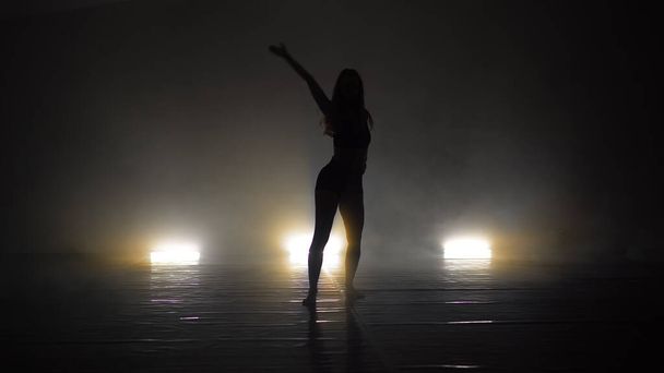 Young beautiful contemporary  ballerina on smoke stage dancing modern ballet - 写真・画像
