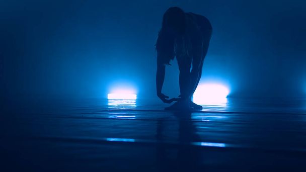Young cool woman dancing erotic sensual dance in club with lights - 写真・画像