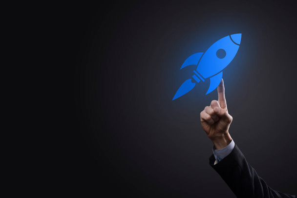 Концепция стартапа с бизнесменом, держащим в руках цифровую ракету, запускается и взлетает. - Фото, изображение