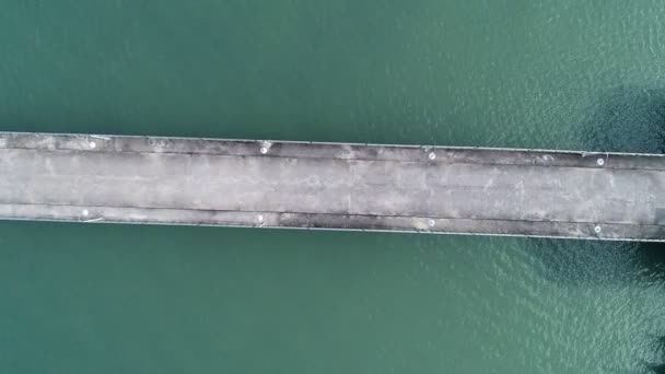 空中ビュートップダウン海の中に長い尾漁船と小さな橋の桟橋美しい熱帯の海の表面高角度ビュー - 映像、動画