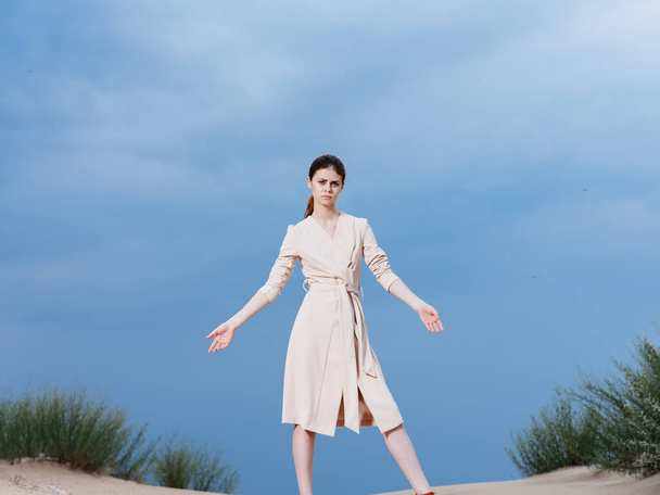 retrato de una mujer en pleno crecimiento en la arena en un modelo de vestido de sol aire fresco naturaleza - Foto, Imagen