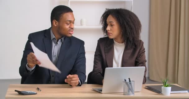Partners coworkers afro american businessman and businesswoman quarreling argue over document data boss showing paper with mistake angry screams scolding female secretary, misunderstanding concept - Footage, Video