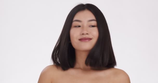 Tökéletes hajápolás. Portré fiatal ázsiai nő játszik vele selymes haj, fehér háttér, lassított felvétel - Felvétel, videó