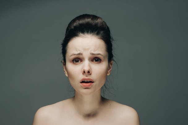 φοβισμένες γυναίκες πρόσωπο γυμνοί ώμοι hairstyle γκρι φόντο μοντέλο - Φωτογραφία, εικόνα