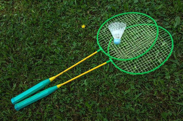 Racchette Badminton con un volano bianco sull'erba verde. Giochi attivi - Foto, immagini