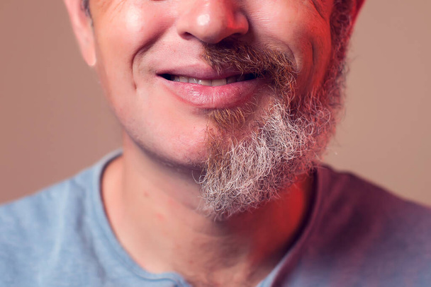 Muotokuva miehestä, jolla on puolikas parta ja hiukset ruskealla taustalla - Valokuva, kuva