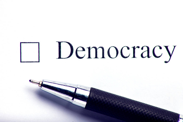 Demokracja - kratka z krzyżykiem na białym papierze. Koncepcja listy kontrolnej. - Zdjęcie, obraz