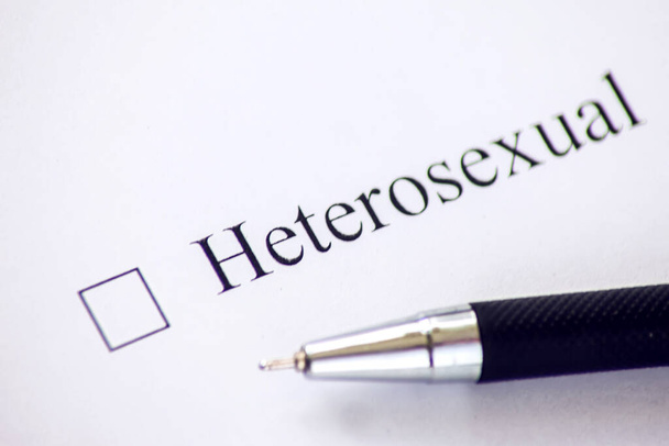 Lista de verificación con una palabra heterosexual en papel blanco con pluma. Concepto de casilla de verificación. - Foto, imagen