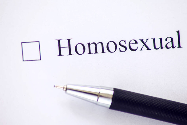 Список со словом "гомосексуалист" на белой бумаге с ручкой. Концепция Checkbox. - Фото, изображение