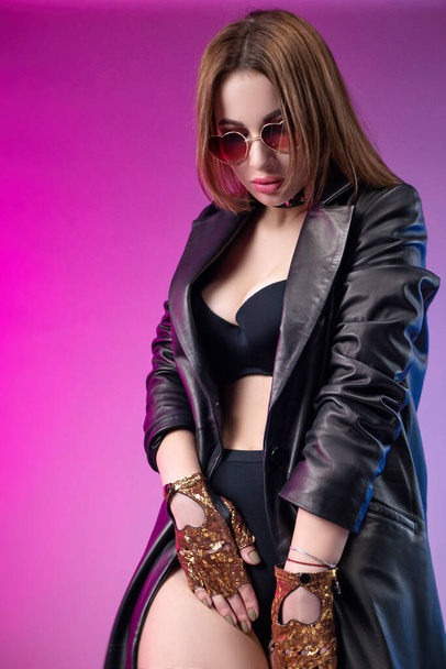 fashionable stylish woman in underwear and leather raincoat on neon background - Fotoğraf, Görsel