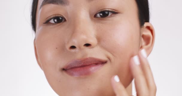 Massaggio lifting facciale. Giovane donna asiatica massaggiare il suo viso per effetto di drenaggio linfatico, bianco studio sfondo - Filmati, video