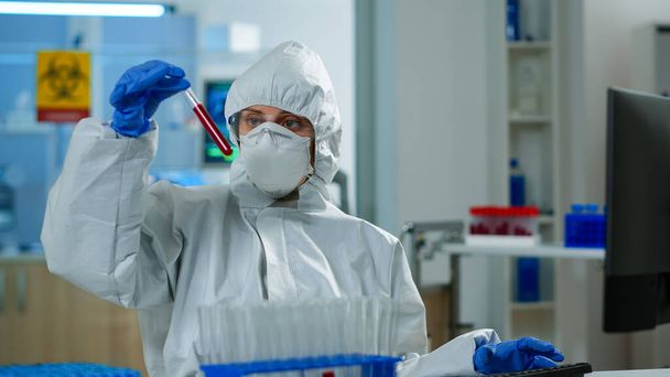 Neurologista com fato-macaco a trabalhar no desenvolvimento da vacina analisando a amostra de sangue - Foto, Imagem