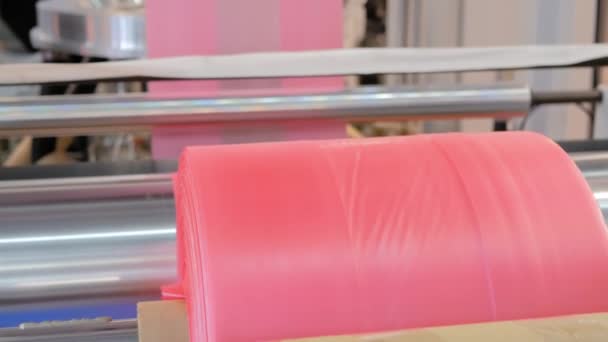 Bezárás: automata műanyag zacskó készítő gép - mozgó henger rózsaszín filmmel - Felvétel, videó