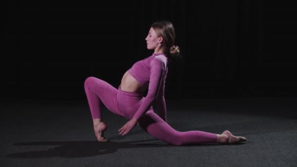 Giovane ginnasta femminile che si allunga le gambe - Filmati, video