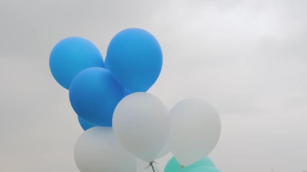 Yakın çekim: Açık hava festivalinde rüzgarda savrulan klorlu balonlar gri gökyüzüne karşı - Video, Çekim