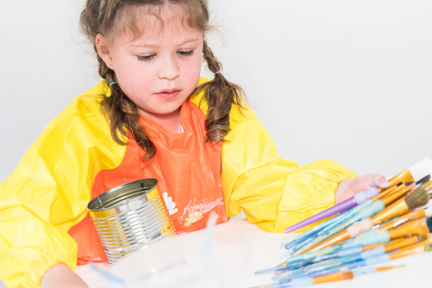 Μικρό κορίτσι που εργάζεται σε ένα έργο τέχνης με ακρυλικό χρώμα στο homeschool. - Φωτογραφία, εικόνα