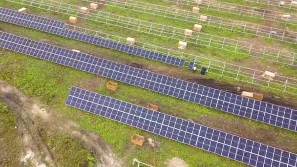緑のフィールド上の建設中の太陽光発電所の空中ビュー。クリーン・エネルギーを生産するための電気パネルの組み立て. - 映像、動画