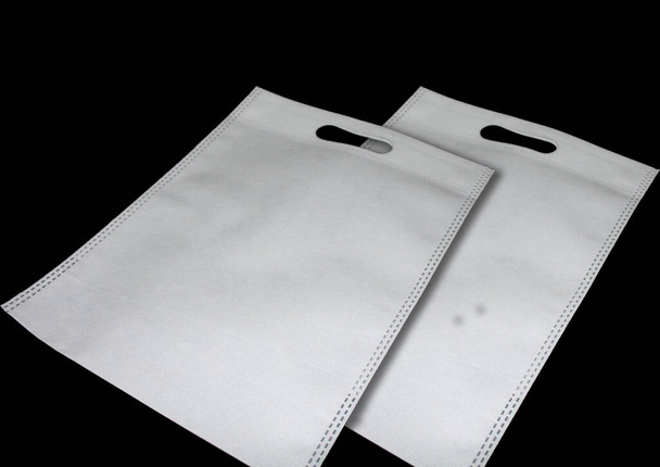 Witte stof niet-geweven D-gesneden tassen. Eco tassen met zwarte achtergrond. Verkoop banner concept. - Foto, afbeelding