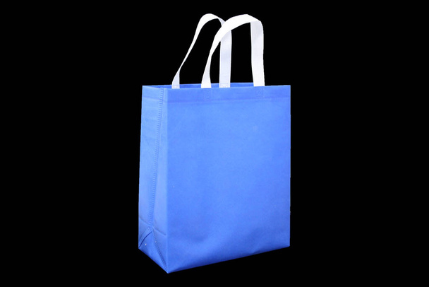 eco friendly bag blue color with white handle on black background, non woven bag, Biodegradable Bag, reduce, reuse, recycle Shopping Bag - Photo, Image
