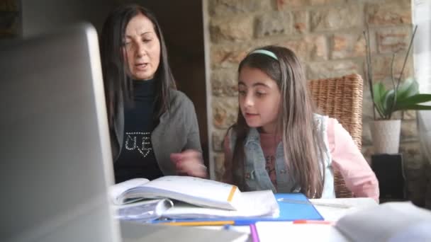 Home schooling, mother and daughter at home making school lesson - Felvétel, videó