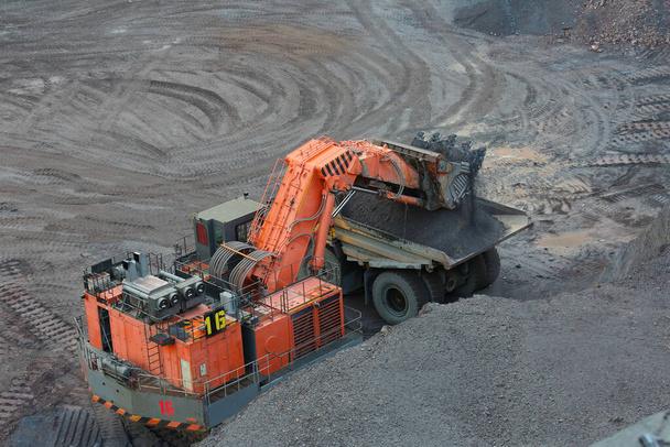 Zware mijnbouw dump truck wordt geladen met ijzererts - Foto, afbeelding
