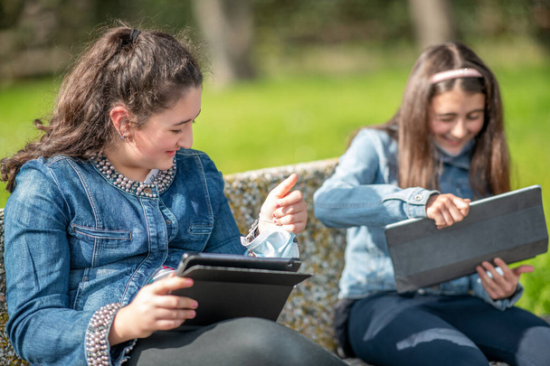 Şehir parkında tablet kullanan iki genç kız.. - Fotoğraf, Görsel