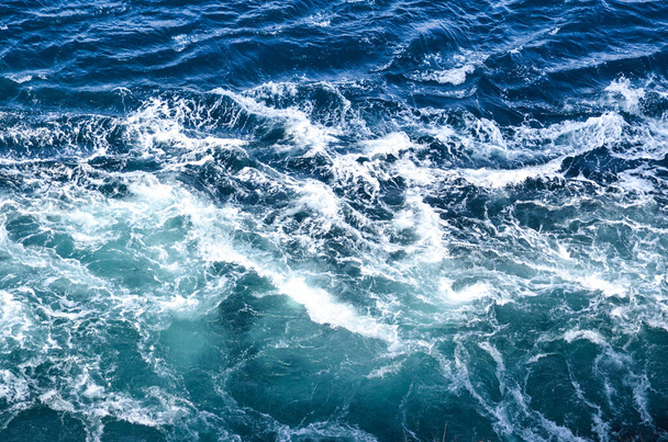 Fondo abstracto. Las olas del agua del mar se encuentran con rocas puntiagudas bajo el agua, formando remolinos. Hidromasajes en la zona de la ciudad noruega de Bodo. Países Bajos - Foto, Imagen