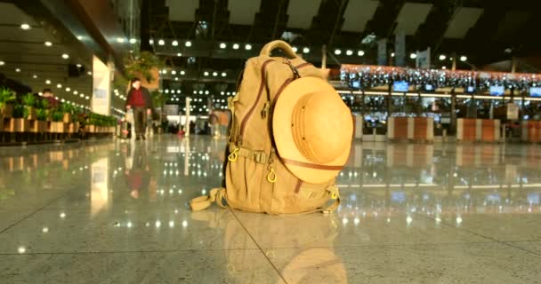 un sac à dos touristique avec un chapeau découverte sur le plancher de l'aéroport - Séquence, vidéo