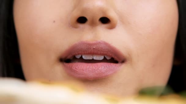 Primo piano di asiatico donna leccare labbra sensualmente mangiare caldi pizza - Filmati, video