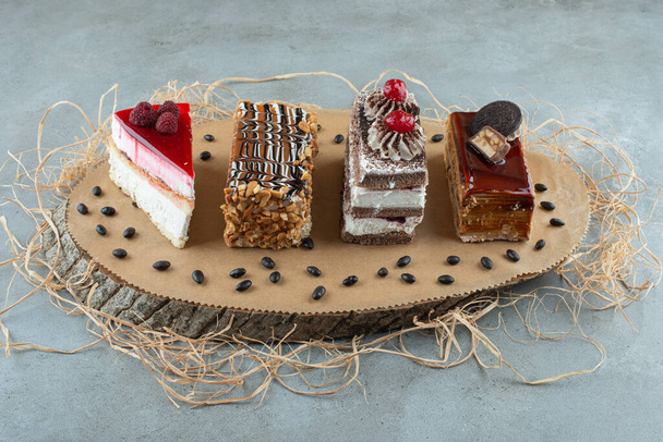 Vier Scheiben verschiedener Kuchen auf Holzstück. Hochwertiges Foto - Foto, Bild