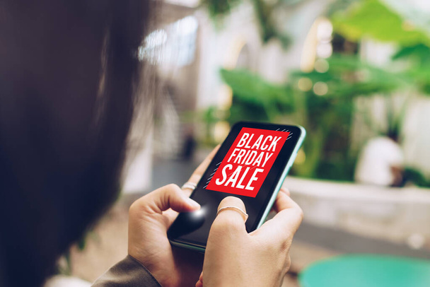 Frauen, die ihr Smartphone benutzen, verkaufen am Black Friday online für Leute, die online einkaufen, mit Chatbox, Warenkorb, Dollarsymbolen. Social-Media-Konzept. - Foto, Bild