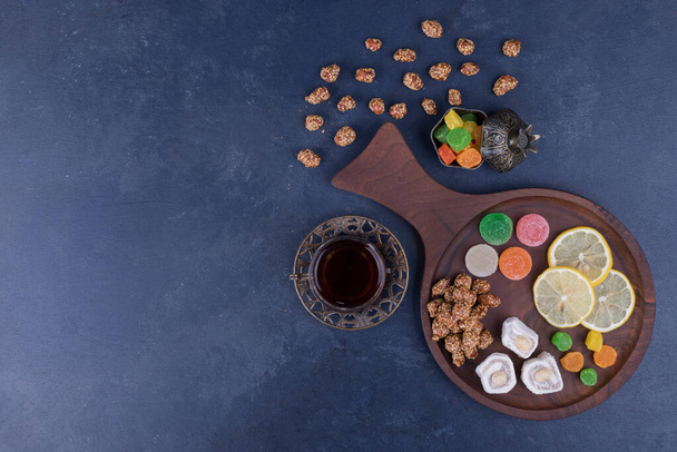 чай и вкусные турецкие деликатесы на фоне стола - Фото, изображение