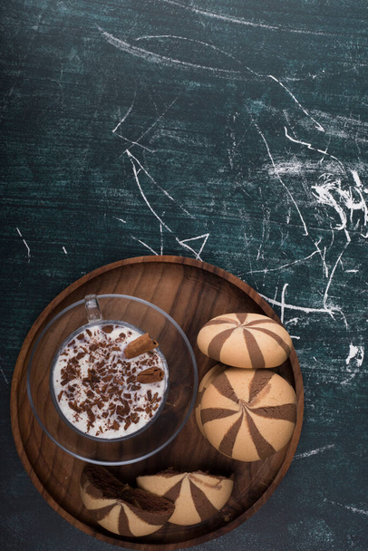 top view of milkshake in glass and chocolate striped cookies - Fotó, kép