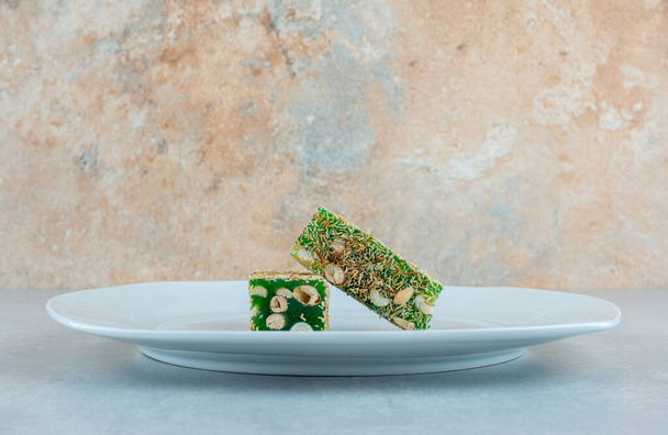 Green colored Turkish delight on the trivet on the marble background. High quality photo - Photo, Image