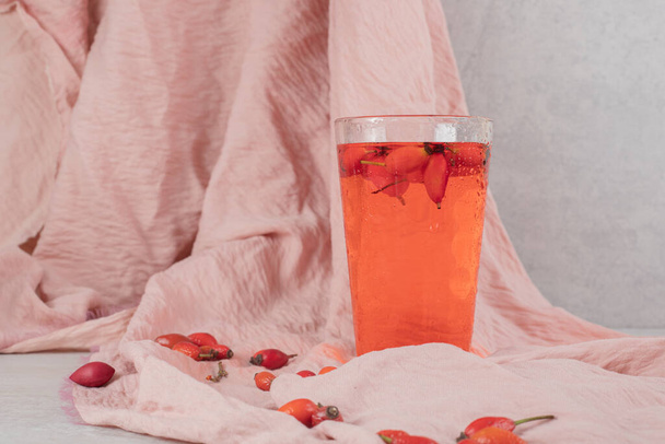 Vaso de limonada fresca con rosa mosqueta sobre tela. Foto de alta calidad - Foto, imagen