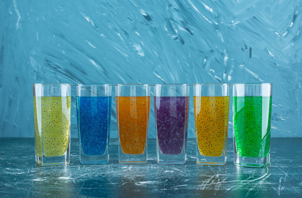 juice glasses lined up on the blue background. High quality photo - Photo, Image