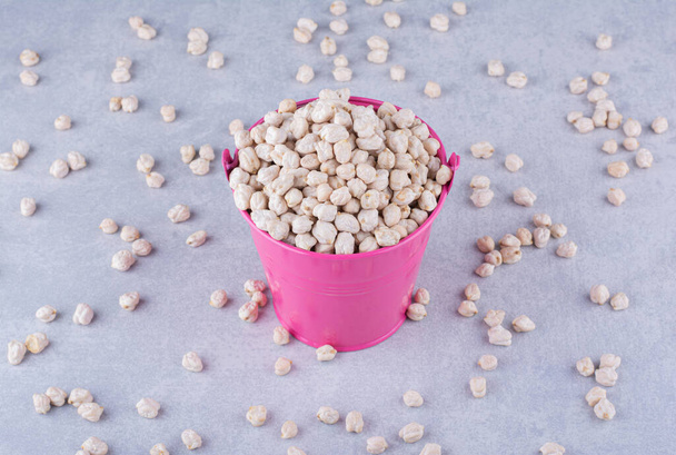 Overfilled bucket of chickpeas on marble background. High quality photo - Photo, Image
