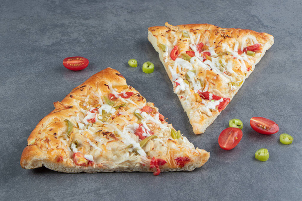 délicieuses tranches de pizza avec du fromage et des légumes sur fond - Photo, image