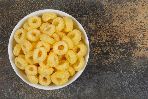 Sabrosos anillos de cereales en tazón blanco. Foto de alta calidad - Foto, Imagen