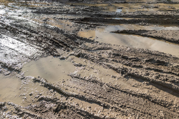 dirty clay mud road with tire tracks at day time - full frame background with hard sun light - Photo, Image