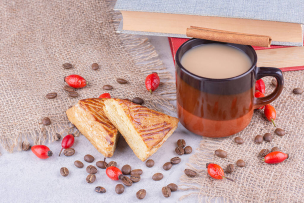 Taza de café con granos de café y pasteles en arpillera. Foto de alta calidad - Foto, imagen