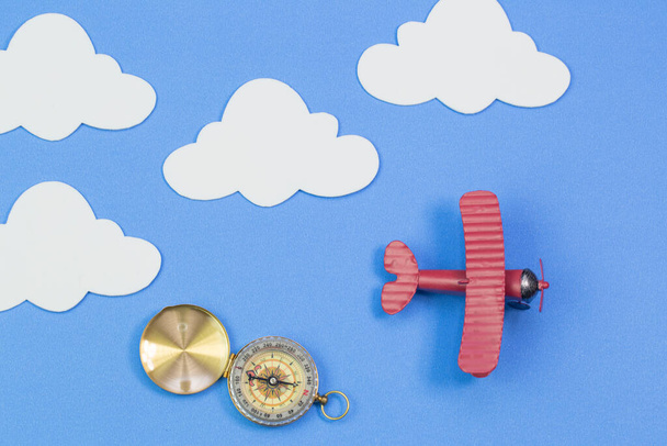 Игрушечный самолет на фоне голубого неба с бумажными облаками - Фото, изображение