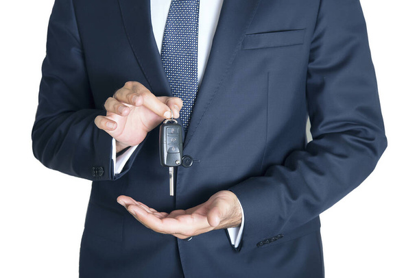 Cropped section of businessman with car key in hand, isolated on white background. - Фото, изображение