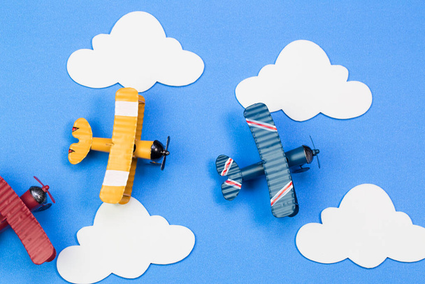 Toy airplanes on a background of blue sky with paper clouds - Photo, Image