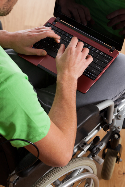 Disabled man typing on laptop - Foto, Imagen