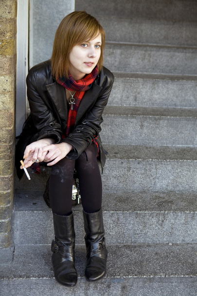 Young woman sitting on the pavement in London - Foto, afbeelding